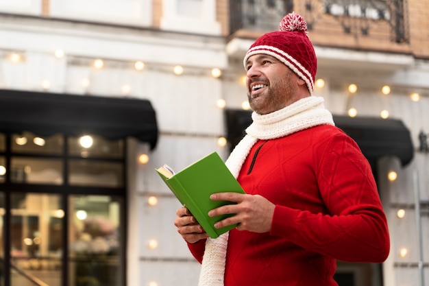 Vista lateral hombre sonriente con libro