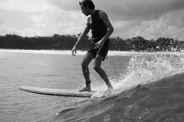 Foto vista lateral de un hombre surfeando en el mar