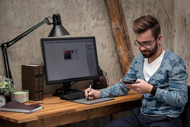 Vista lateral de un hombre usando una computadora portátil mientras está sentado en la mesa