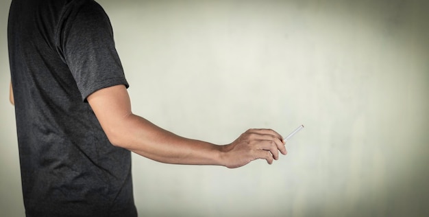 Foto vista lateral de un hombre usando el teléfono móvil contra la pared