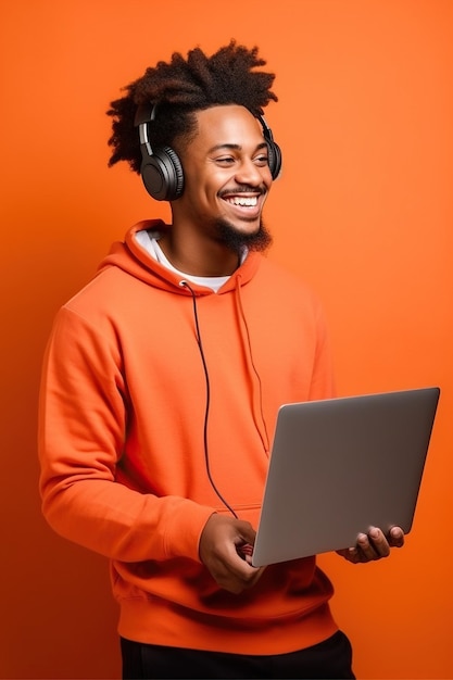 Vista lateral jovem sorridente homem afro-americano usa camiseta roupas casuais segurar uso ponto de trabalho em laptop computador navegação na internet isolado em laranja cor vermelha fundo estúdio