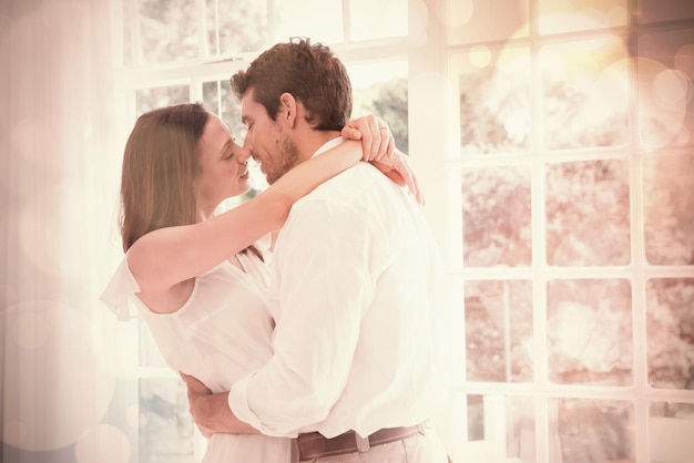 Vista lateral de una joven pareja amorosa a punto de besarse en casa