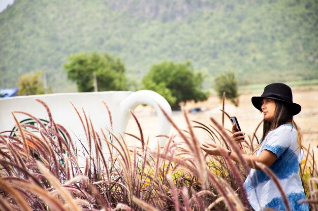 Foto vista lateral de un joven de pie junto a las plantas en el campo