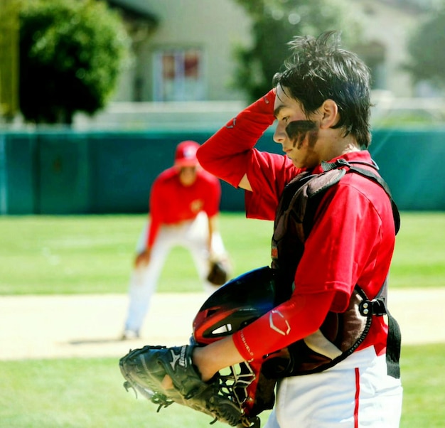 Foto vista lateral de un jugador de béisbol en el campo