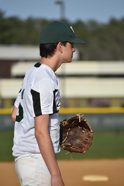 Foto vista lateral de un jugador de béisbol con guantes