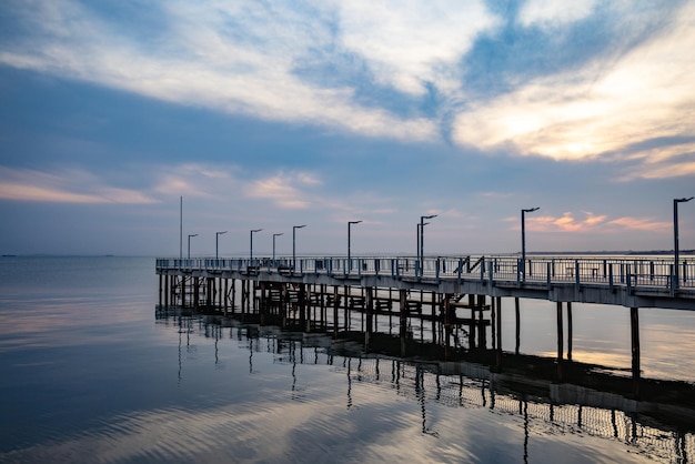 Vista lateral del muelle en el Mar Negro contra el fondo del cielo y la puesta de sol