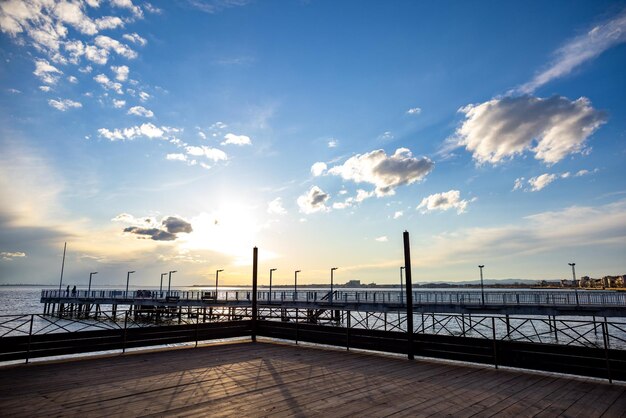 Vista lateral del muelle en el Mar Negro contra el fondo del cielo y la puesta de sol