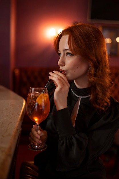 Vista lateral mujer bebiendo cóctel