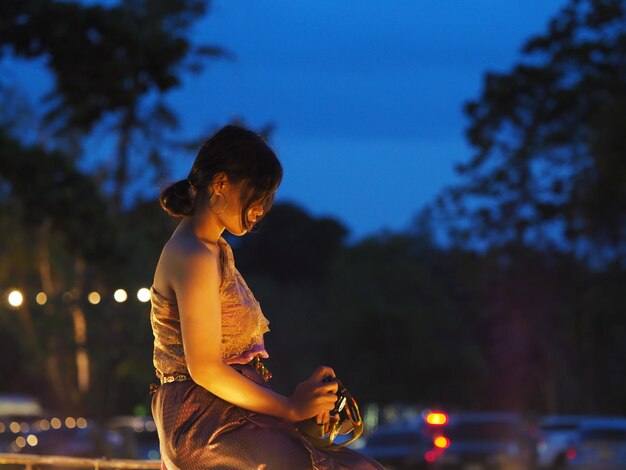 Foto vista lateral de una mujer contra el cielo nocturno