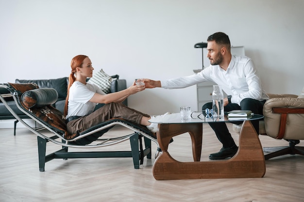 Vista lateral La mujer está sentada en una silla en una cita con un psicólogo