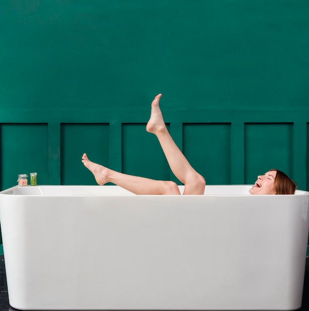 Foto vista lateral de una mujer feliz en la bañera