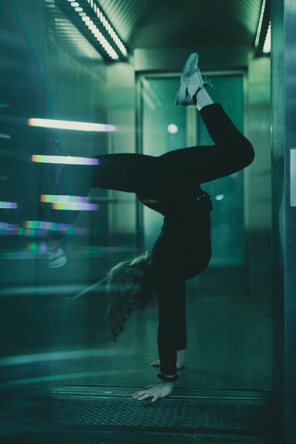 Vista lateral de una mujer haciendo handstand en la puerta