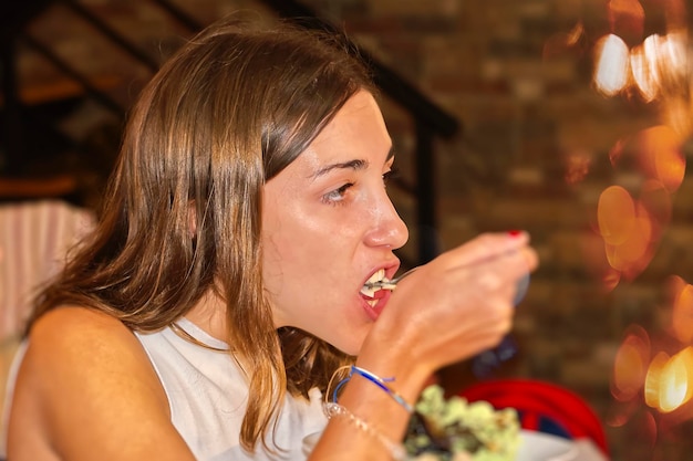 Foto vista lateral de una mujer joven bebiendo un vaso