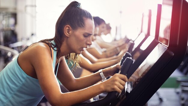 Foto vista lateral de una mujer joven haciendo ejercicio en el gimnasio