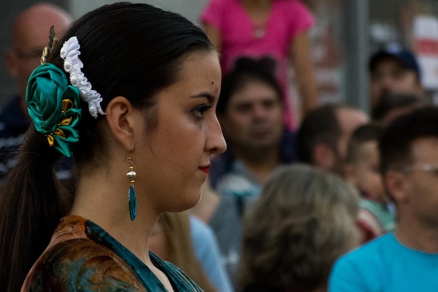 Foto vista lateral de una mujer joven con pendiente y accesorio para el cabello al aire libre