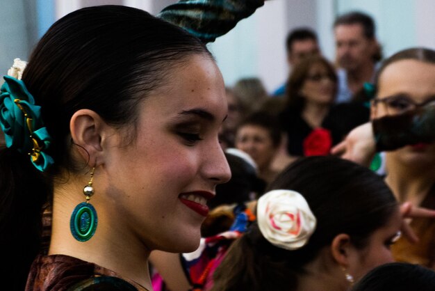 Foto vista lateral de una mujer joven con pendiente y accesorio para el cabello al aire libre