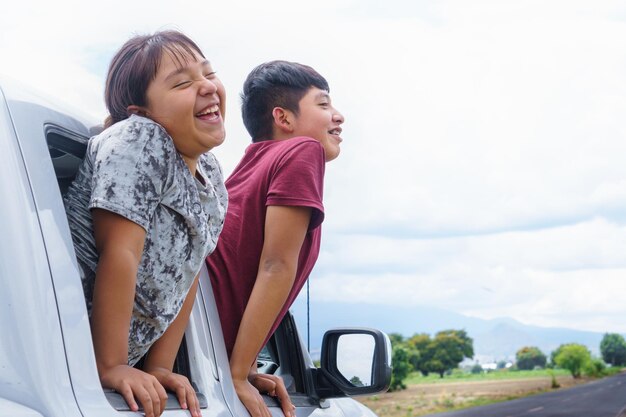 Foto vista lateral de una mujer joven sentada en un coche contra el cielo