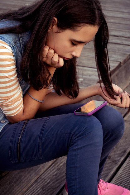 Foto vista lateral de una mujer joven sentada en el suelo de madera dura