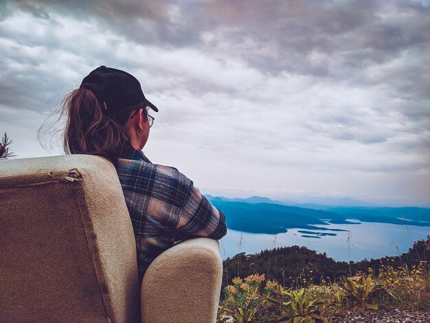 Foto vista lateral de una mujer mirando hacia otro lado contra la montaña