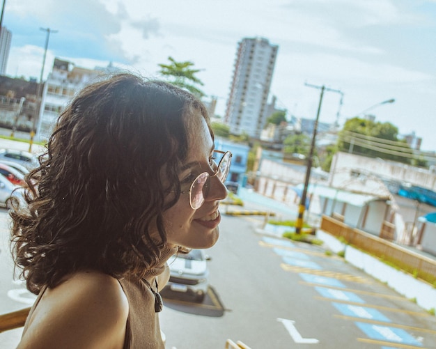 Foto vista lateral de una mujer mirando hacia otro lado mientras está de pie en la ciudad