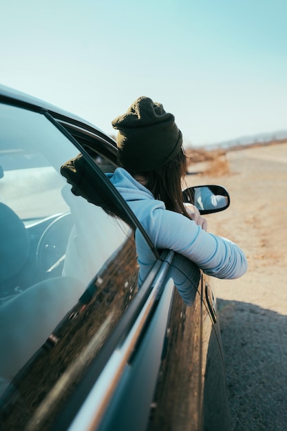 Foto vista lateral de una mujer mirando a través de la ventana del coche