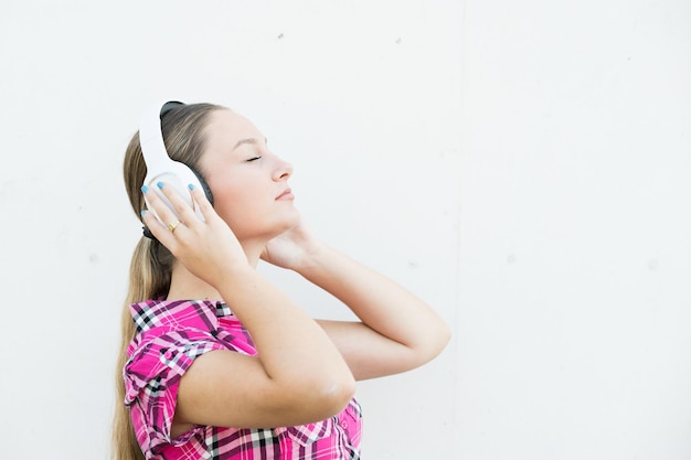 Vista lateral de una mujer muy joven escuchando música relajante