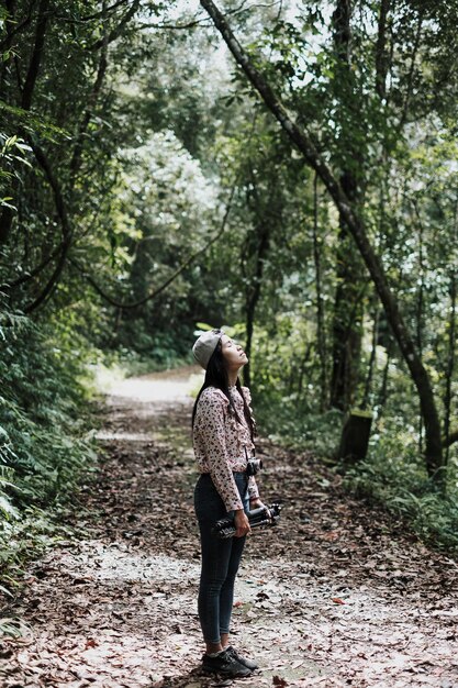 Foto vista lateral de una mujer con los ojos cerrados de pie en el bosque