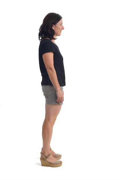 Foto vista lateral de una mujer con pantalones cortos en fondo blanco