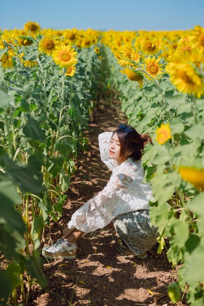 Foto vista lateral de una mujer de pie en plantas con flores