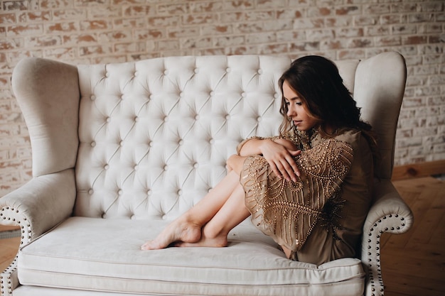 Foto vista lateral de una mujer sentada en el sofá en casa