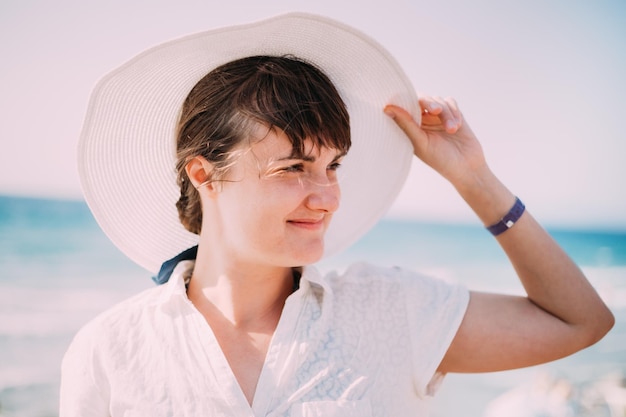 Vista lateral de una mujer con sombrero contra un cielo despejado