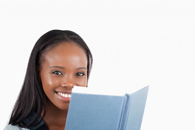 Vista lateral de la mujer sonriente leyendo un libro