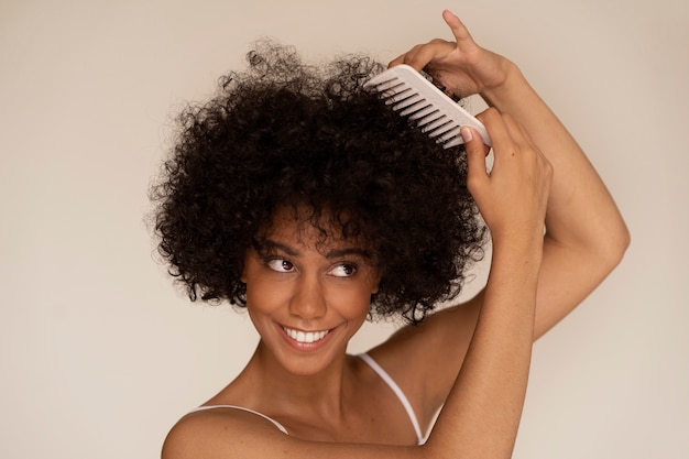 Foto vista lateral mujer sonriente con peine para el cabello