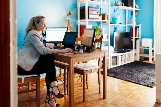 Vista lateral de una mujer usando una computadora en casa