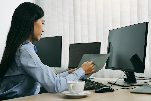 Vista lateral de una mujer usando una computadora portátil en la mesa