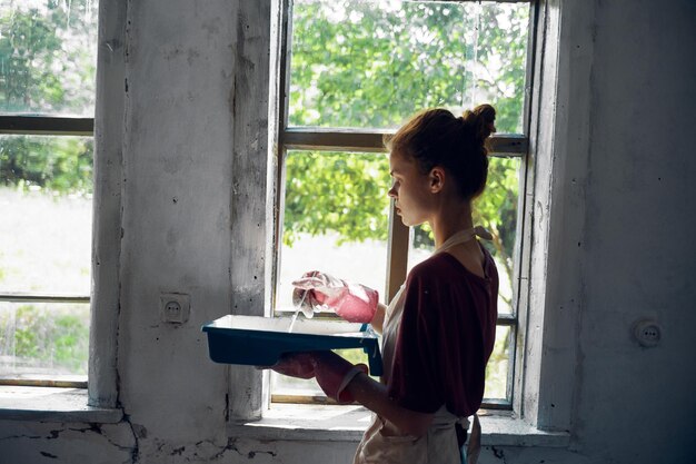 Foto vista lateral de una mujer usando una tableta digital mientras está de pie frente a la casa