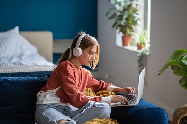 Vista lateral de una mujer usando el teléfono móvil mientras está acostada en la cama en casa