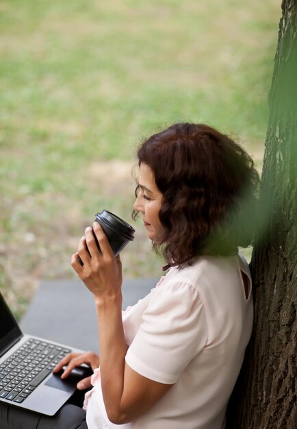 Foto vista lateral de una mujer usando un teléfono móvil