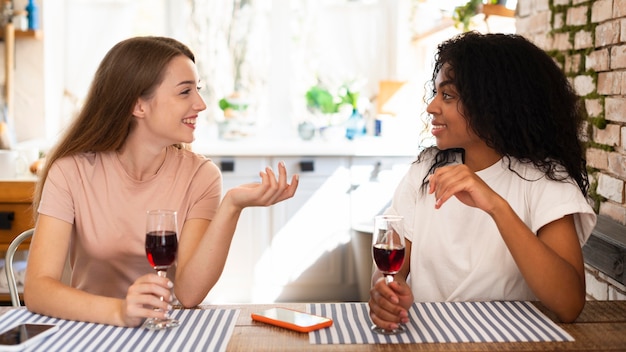 Foto vista lateral, de, mujeres, conversar, encima, copa de vino