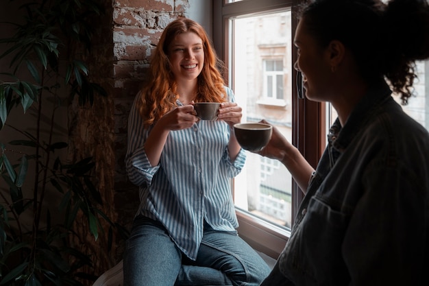 Foto vista lateral mulheres bebendo café