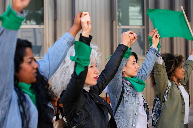 Foto vista lateral mulheres protestando ao ar livre