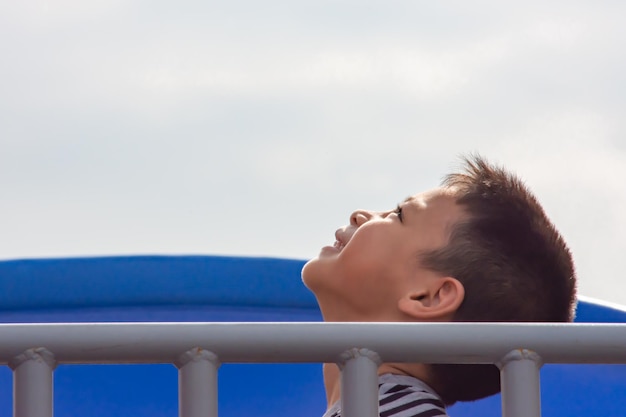 Foto vista lateral de un niño mirando hacia el cielo