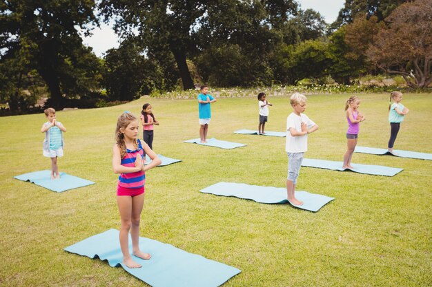 Vista lateral de niños haciendo yoga