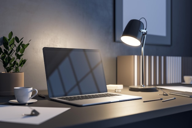 Vista lateral en la pantalla de un portátil oscuro en blanco con espacio de copia para su texto o logotipo en una mesa de madera oscura con una elegante lámpara iluminada de taza de té y una maceta de flores en la maqueta de renderizado 3D de la oficina nocturna