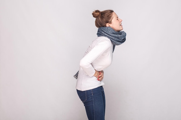 Vista lateral. Períodos, conceito mensal, mensal. A jovem mulher tem um estômago. Foto de estúdio