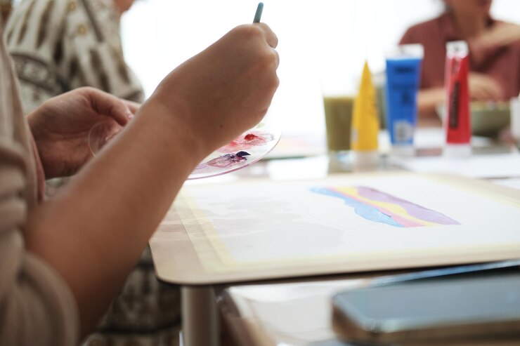 Foto vista lateral de primer plano de la mano de una mujer joven sosteniendo un pincel para pintar