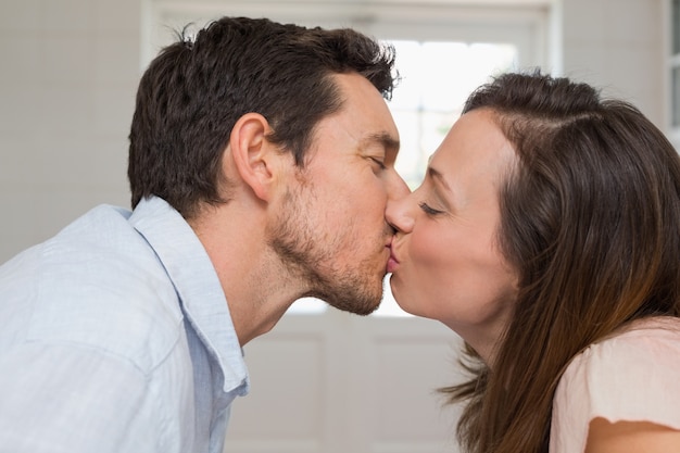 Foto vista lateral de primer plano de una pareja amorosa besándose