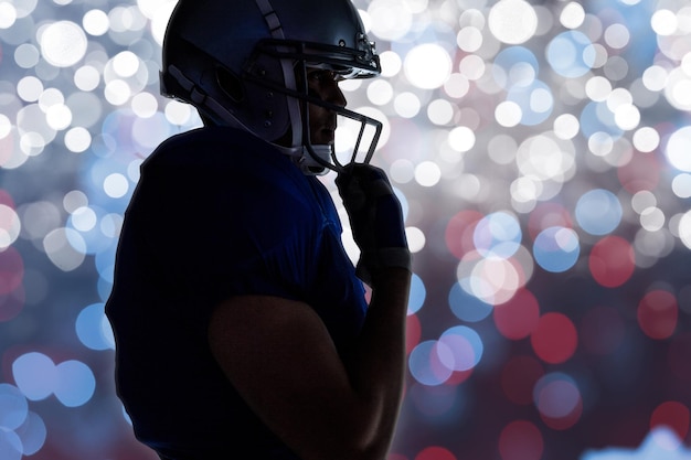 Vista lateral de la silueta del jugador de fútbol americano con casco contra un fondo brillante