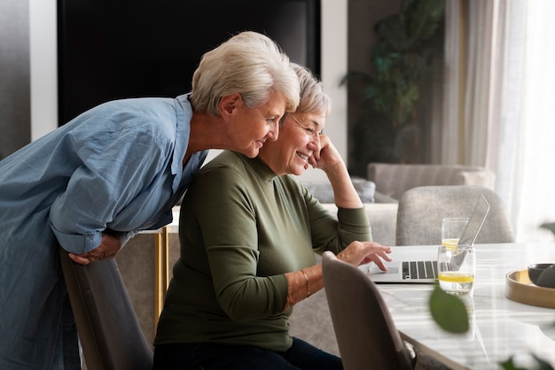 Vista lateral sonriente pareja queer con laptop