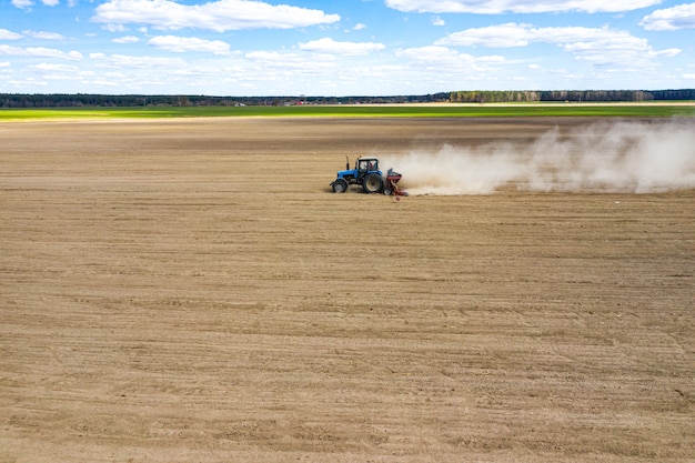 Vista lateral del tractor plantar semillas de maíz en el campo, vista aérea